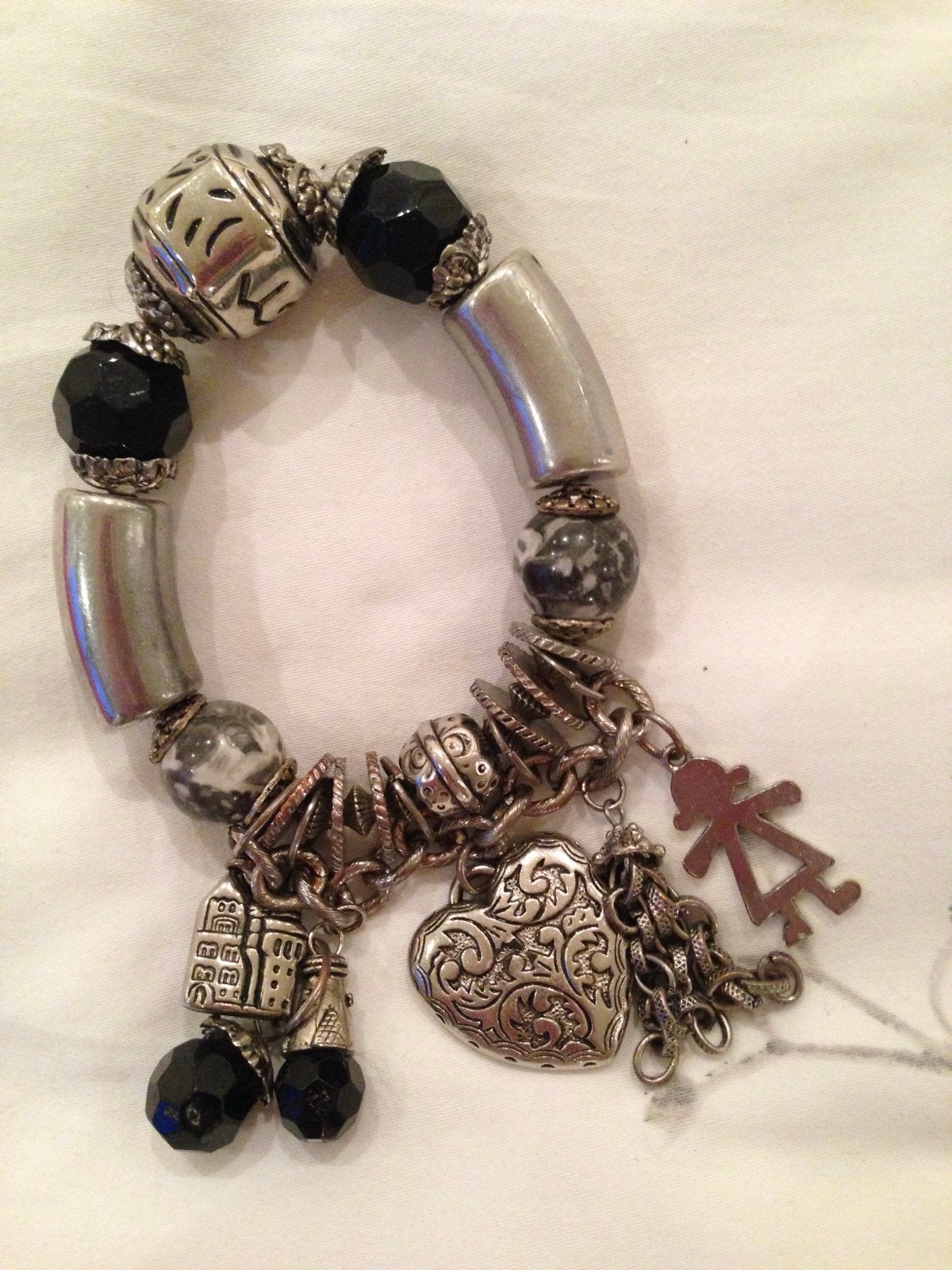 Stoere elastieken armband met zilverkleurige bedels, Gebruikt, Ophalen of Verzenden, Elastiek, Met bedels of kralen