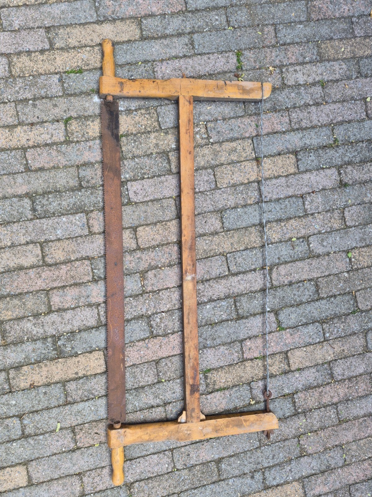 Oude handzaag met houten frame, Ophalen