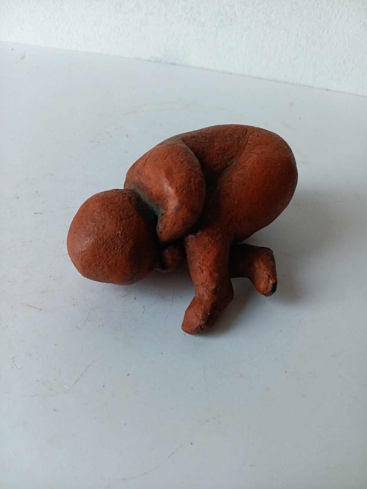 Een terracotta sculptuur van een kind, liggend/zittend, Antiek en Kunst, Kunst | Beelden en Houtsnijwerken, Overige onderwerpen