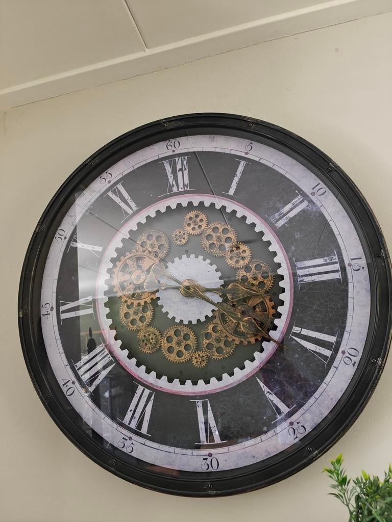Grote wandklok met roterende tandwielen, Ophalen