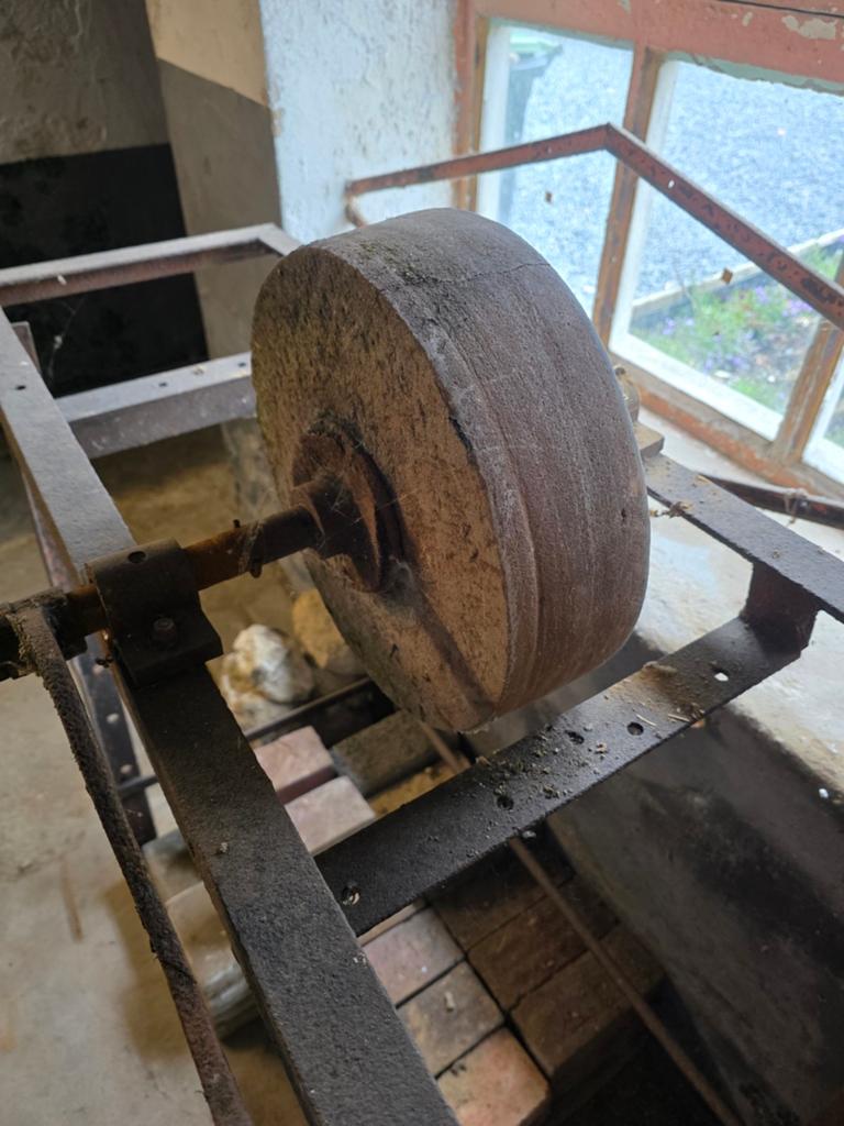 Oude handmatige slijpsteen op frame, Ophalen