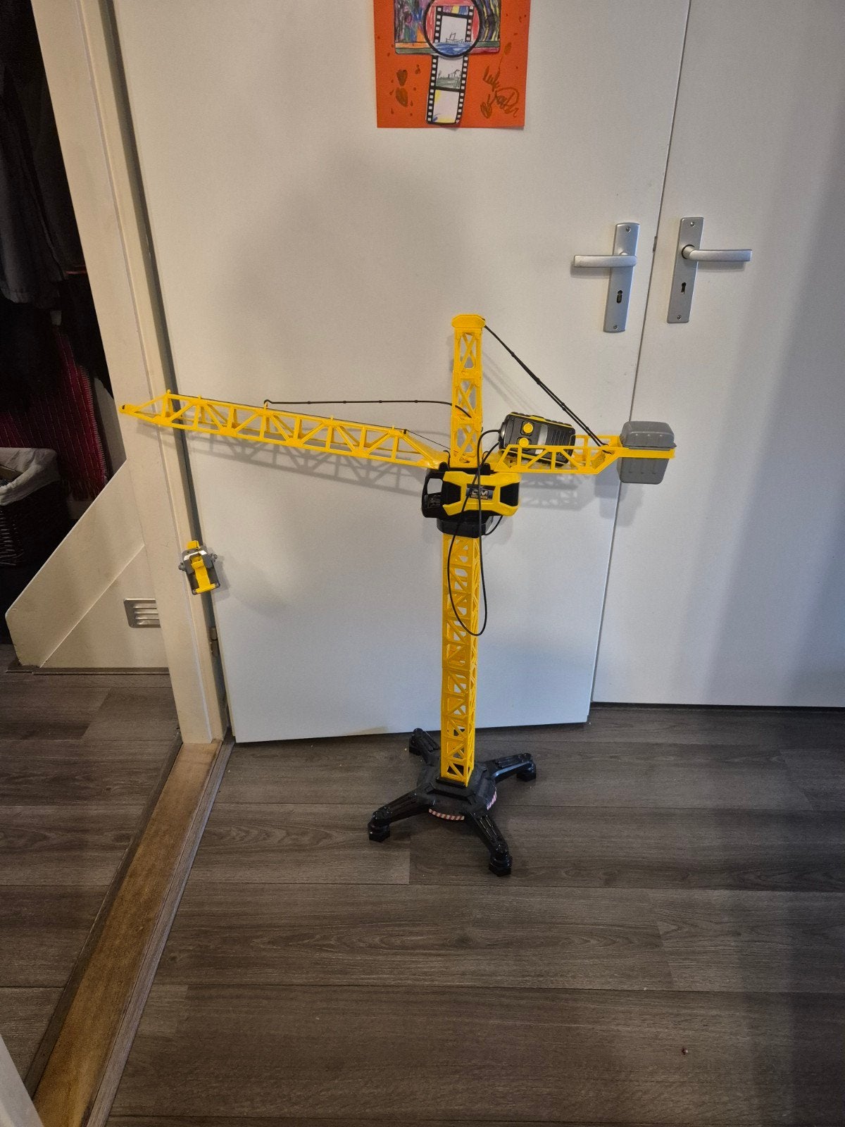 leuke speelgoed hijskraan draait en hijst, Ophalen