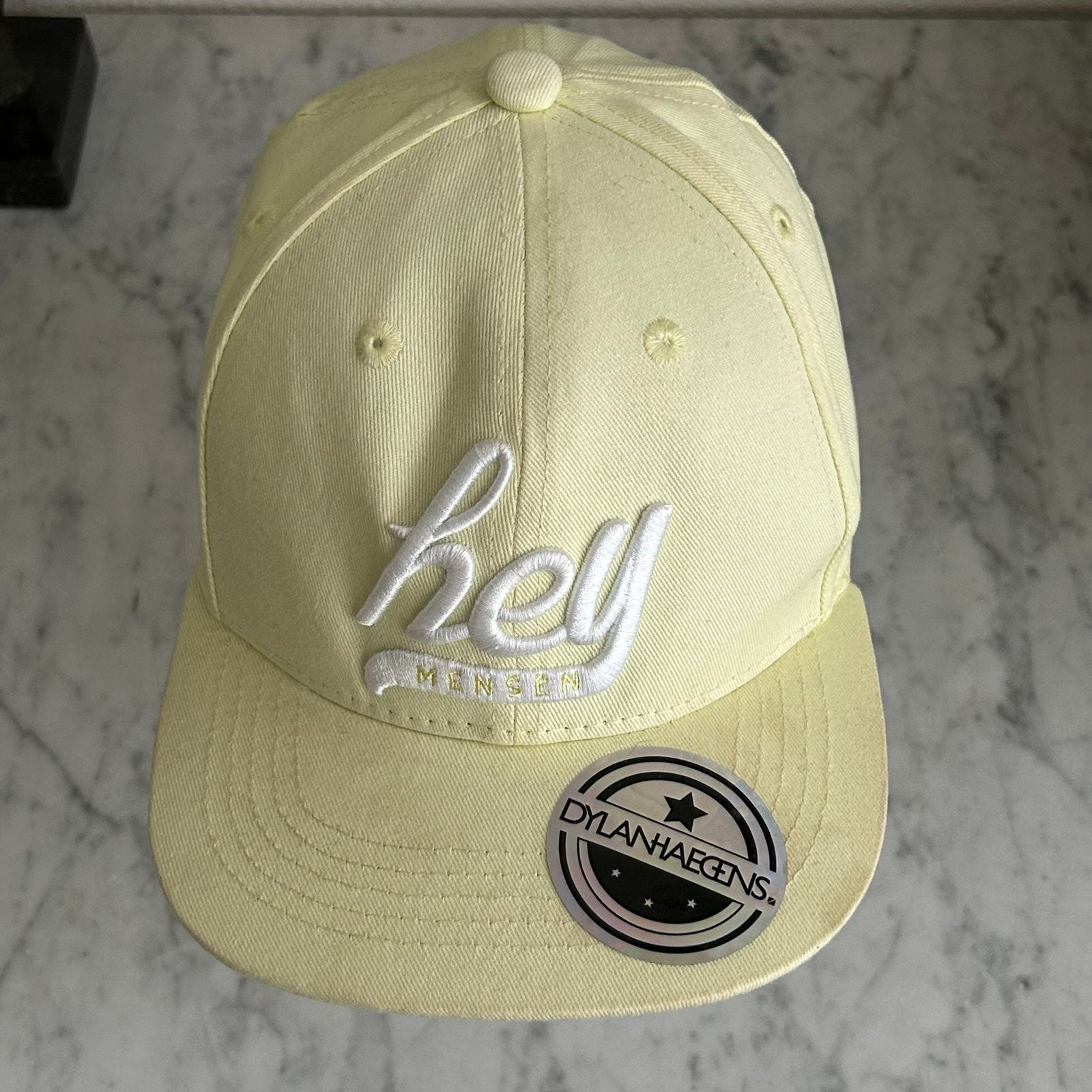 Originele Dylan Haegens 'Hey Mensen' pet geel in NIEUW staat, Ophalen of Verzenden, Zo goed als nieuw, One size fits all, Pet