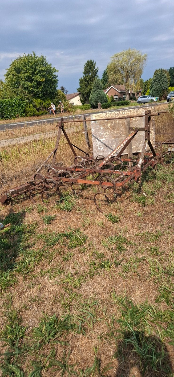 Oude cultivator met rol voor grondbewerking, Ophalen