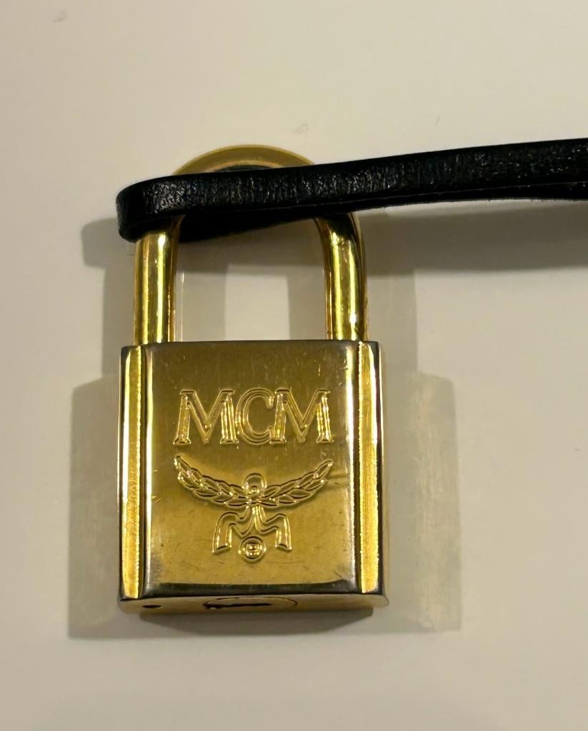 MCM goudkleurig slot in zwarte hoes, Sieraden, Tassen en Uiterlijk, Tassen | Damestassen, Ophalen of Verzenden, Nieuw, Overige kleuren