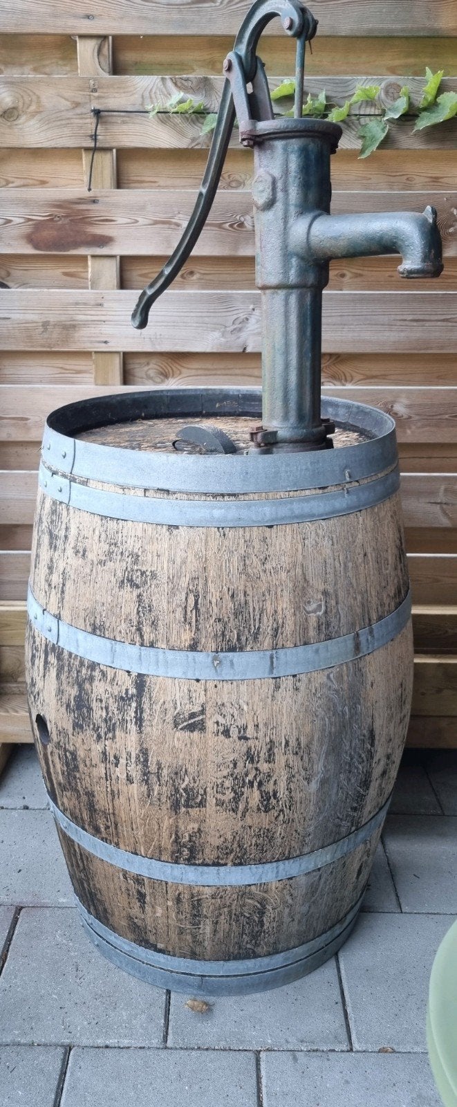 Houten regenton van wijnvat met gietijzeren handpomp