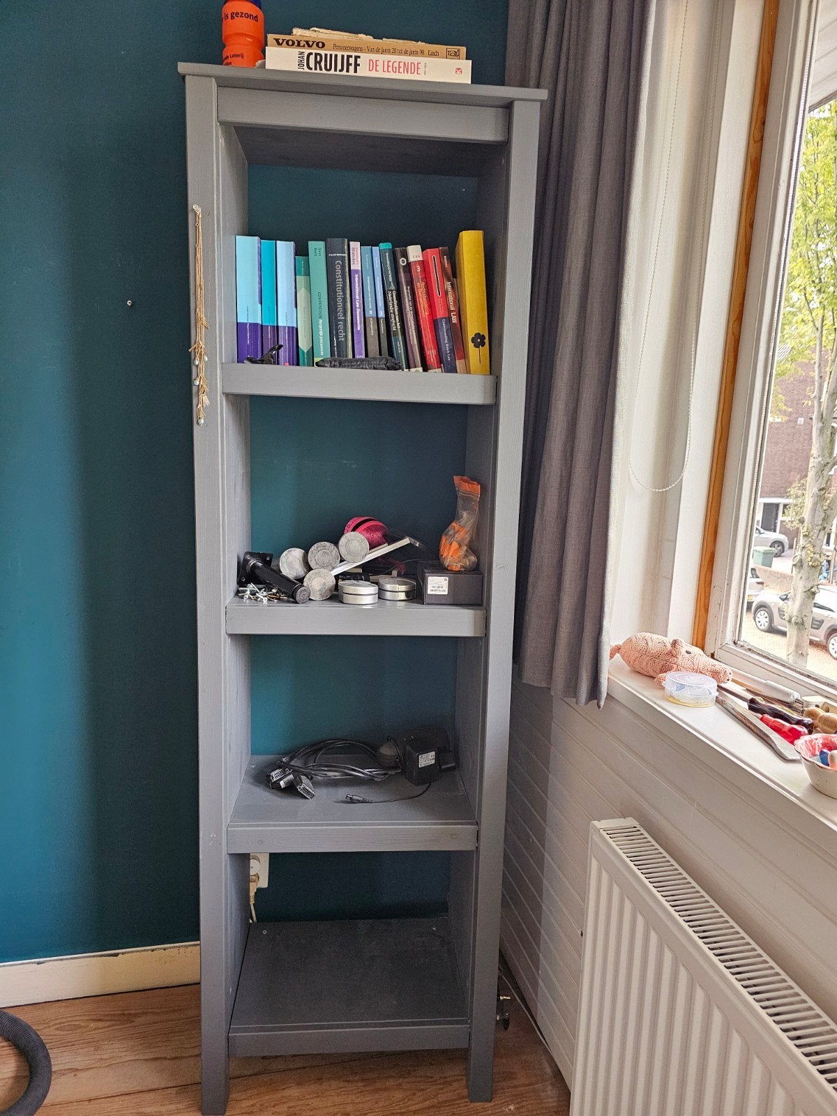 Grijze boekenkast van hout. hoog 1.80 breed 9.55 diep 0.35.