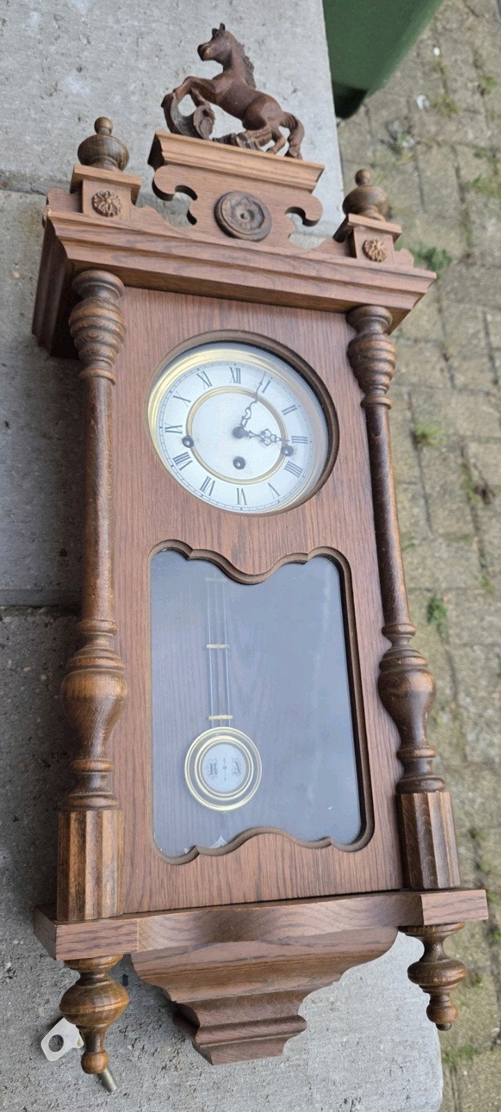 Antieke wandklok met paard en slinger, Ophalen