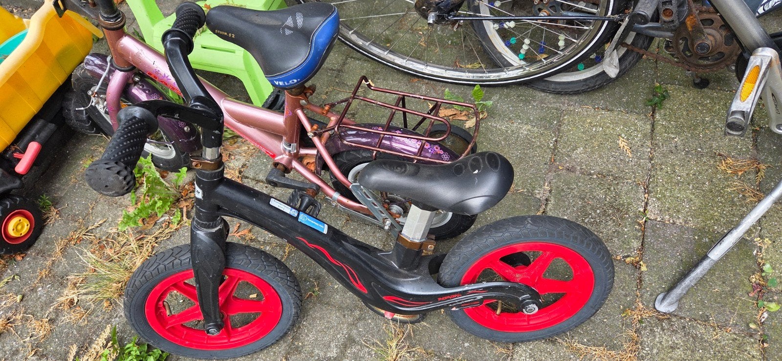 Zwarte loopfiets met rode wielen, Ophalen