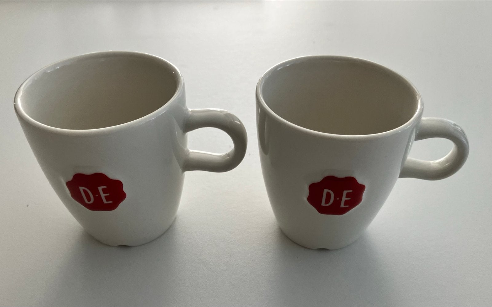 Set van 2 Douwe Egberts koffiemokken Raja Europe, Overige merken, Keramiek, Zo goed als nieuw, Modern
