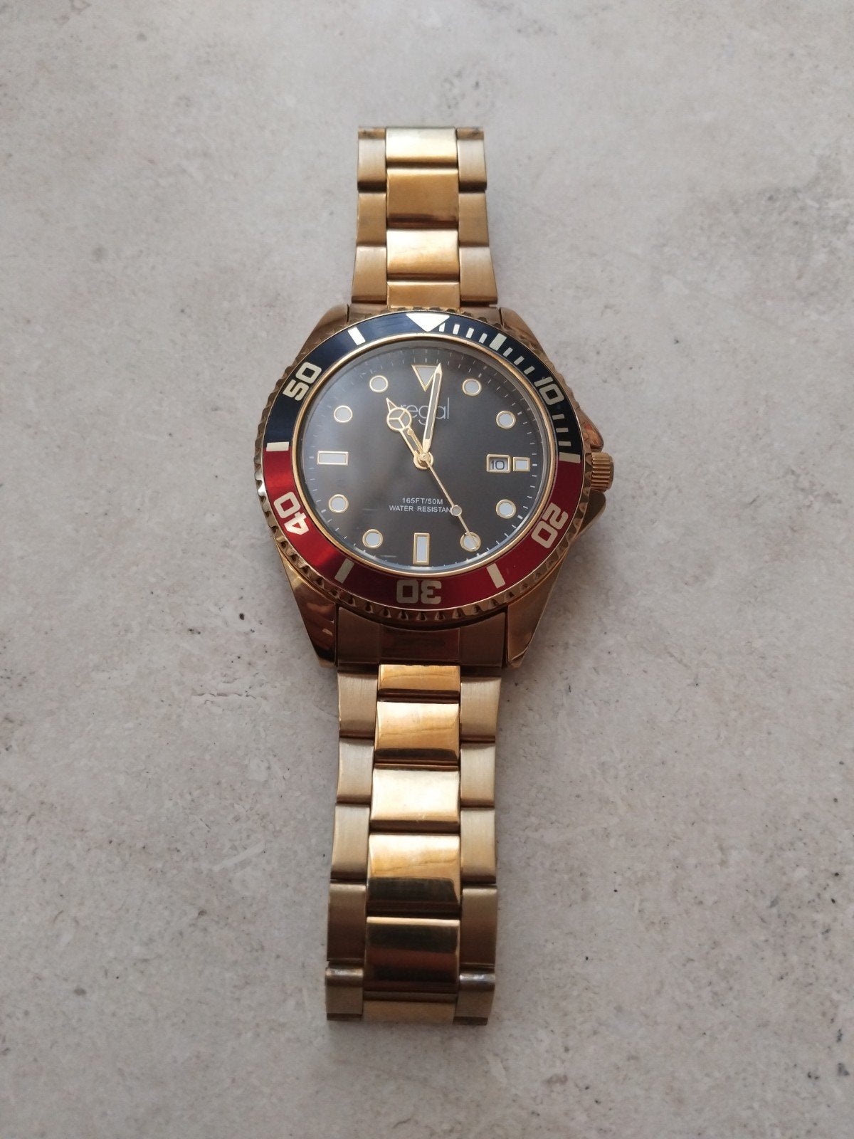 Regal Herenhorloge Goudkleurig met Zwart/Rode Bezel, Sieraden, Tassen en Uiterlijk, Horloges | Heren, Ophalen of Verzenden, Zo goed als nieuw
