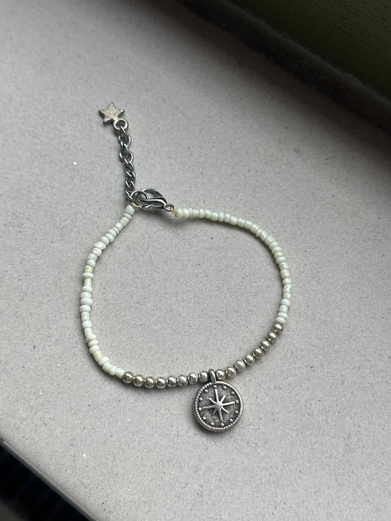 Witte kralen armband met zilveren bedel kompas, Gebruikt, Wit, Ophalen of Verzenden, Elastiek