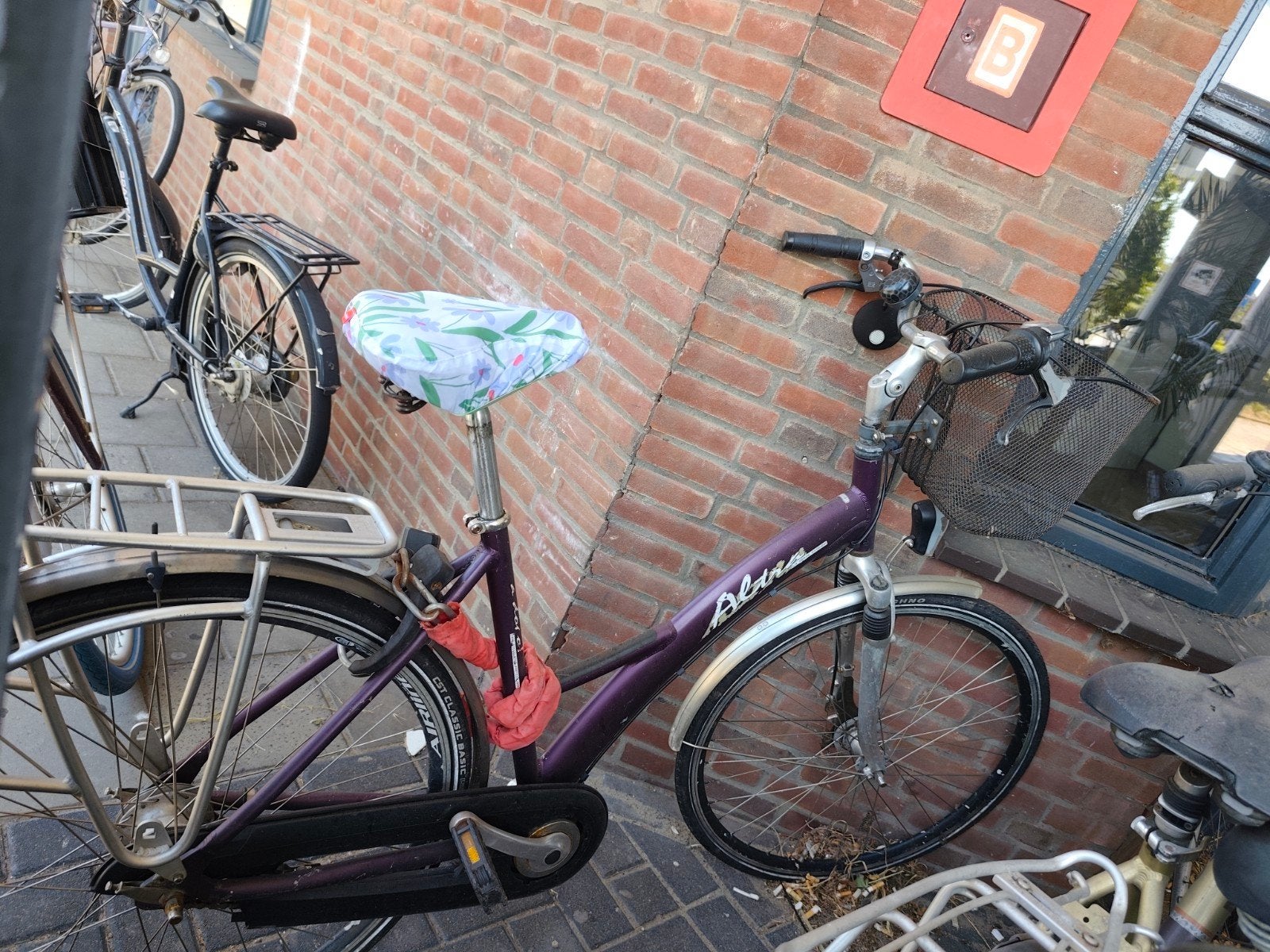 Paarse fiets met twee sloten en mandje, Ophalen