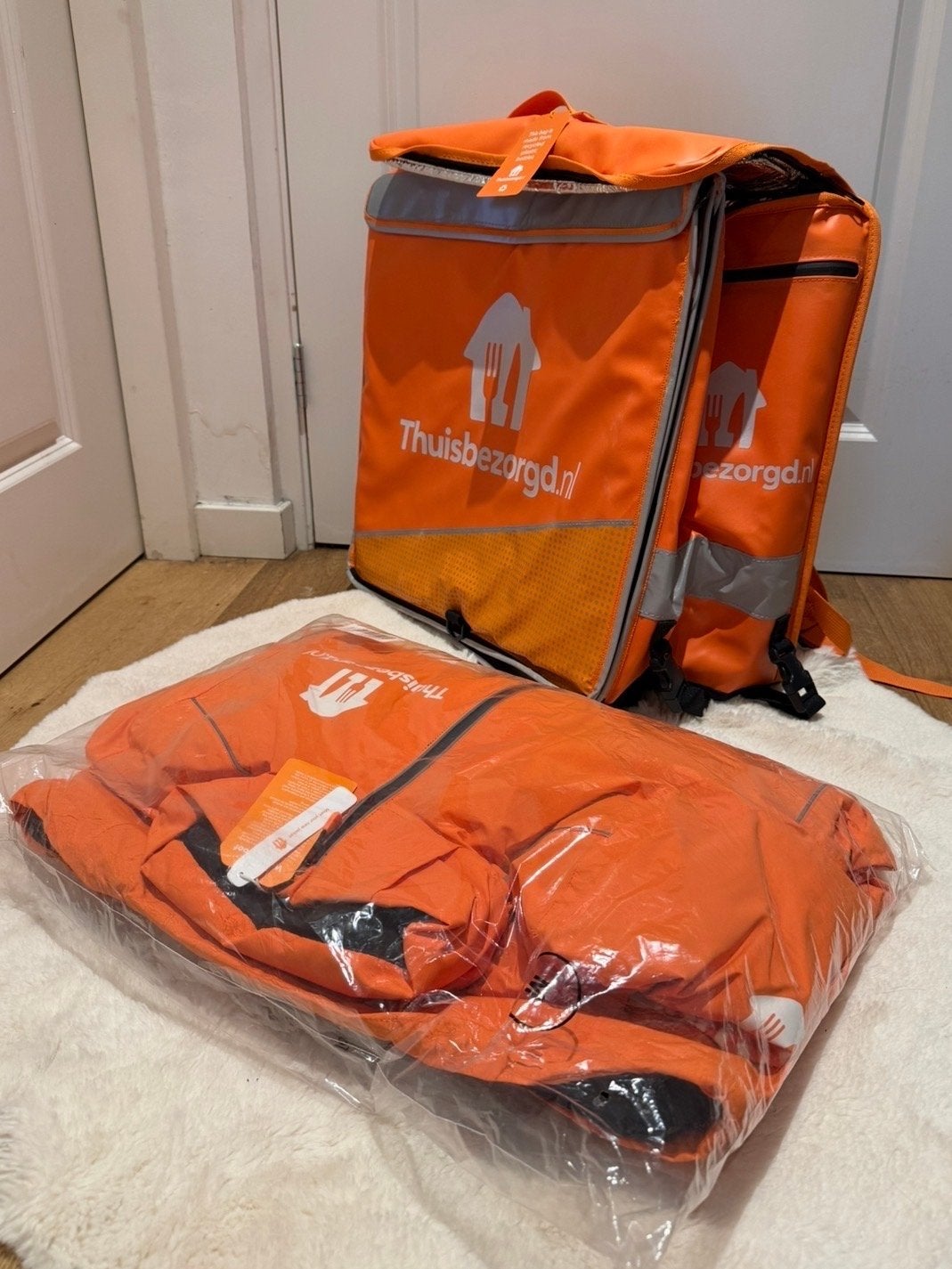 Thuisbezorgd bezorgtas en jas - Nieuw M, Ophalen of Verzenden, Nieuw, Overige maten, Oranje
