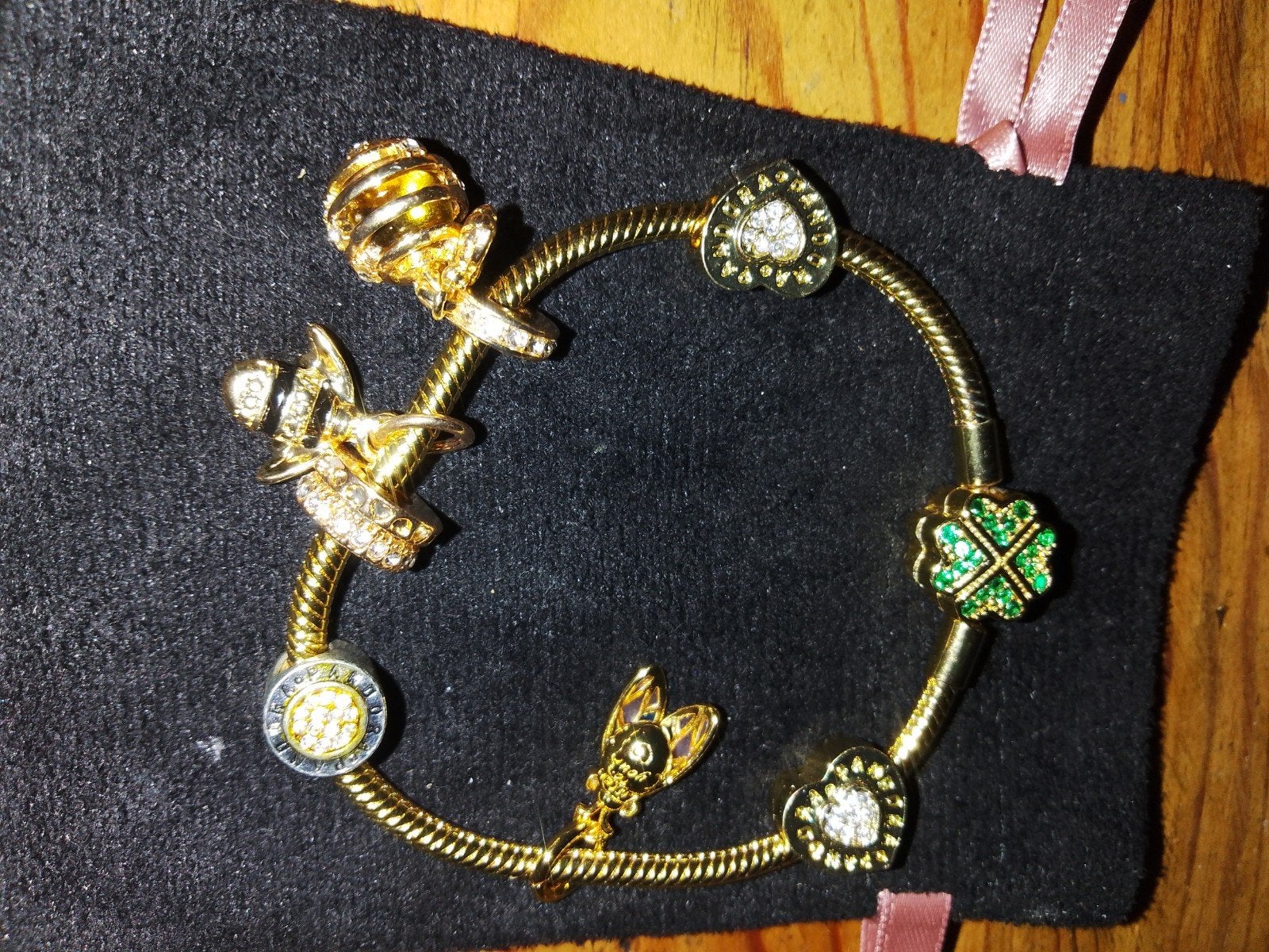 Goudkleurige bedelarmband met klaver 4 sluiting en 7 bedels, Ophalen of Verzenden, Zo goed als nieuw, Overige materialen