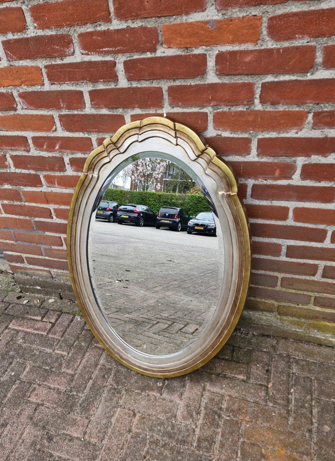 Een spiegel met een gouden en zilveren rand., Antiek en Kunst, Antiek | Spiegels, Ophalen of Verzenden, Ovaal