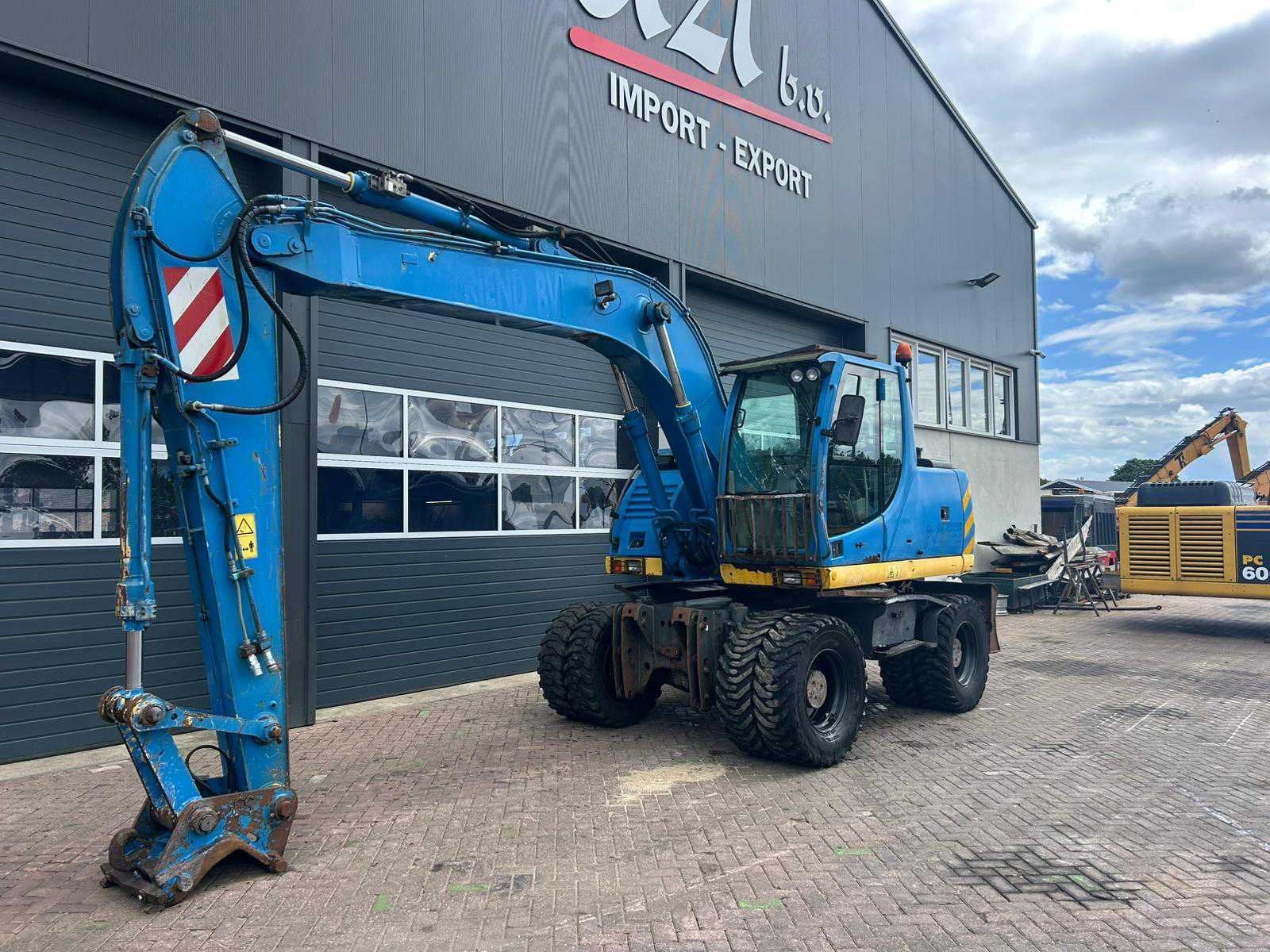 2007 New Holland MH Plus Banden graafmachine, Zakelijke goederen, Machines en Bouw | Kranen en Graafmachines, Graafmachine