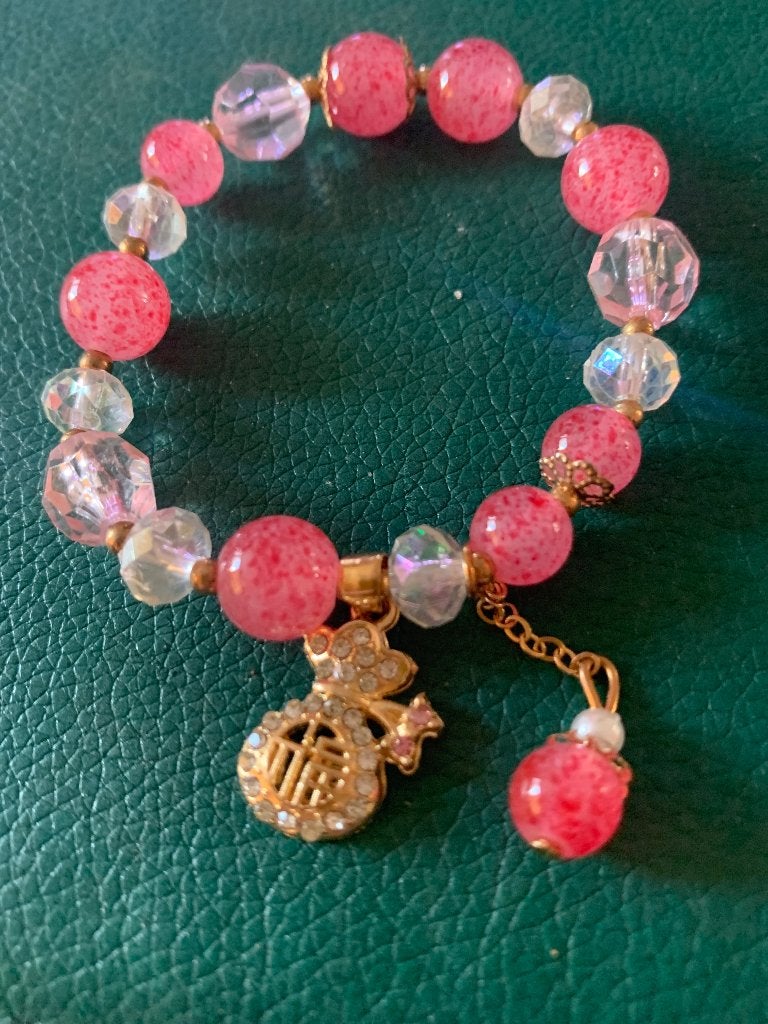 Rozewitte Armbandje met bedels, Sieraden, Tassen en Uiterlijk, Armbanden, Ophalen of Verzenden, Zo goed als nieuw, Elastiek, Roze