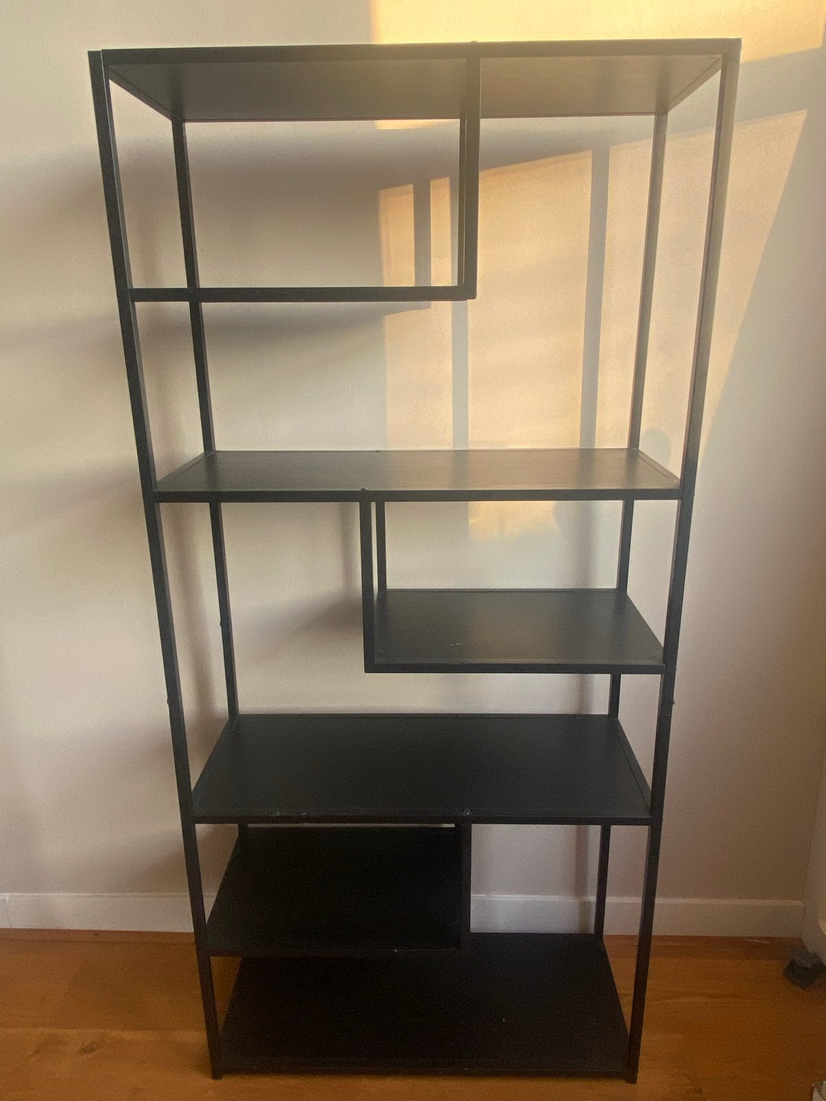 Zwart metalen open kast met asymmetrische planken