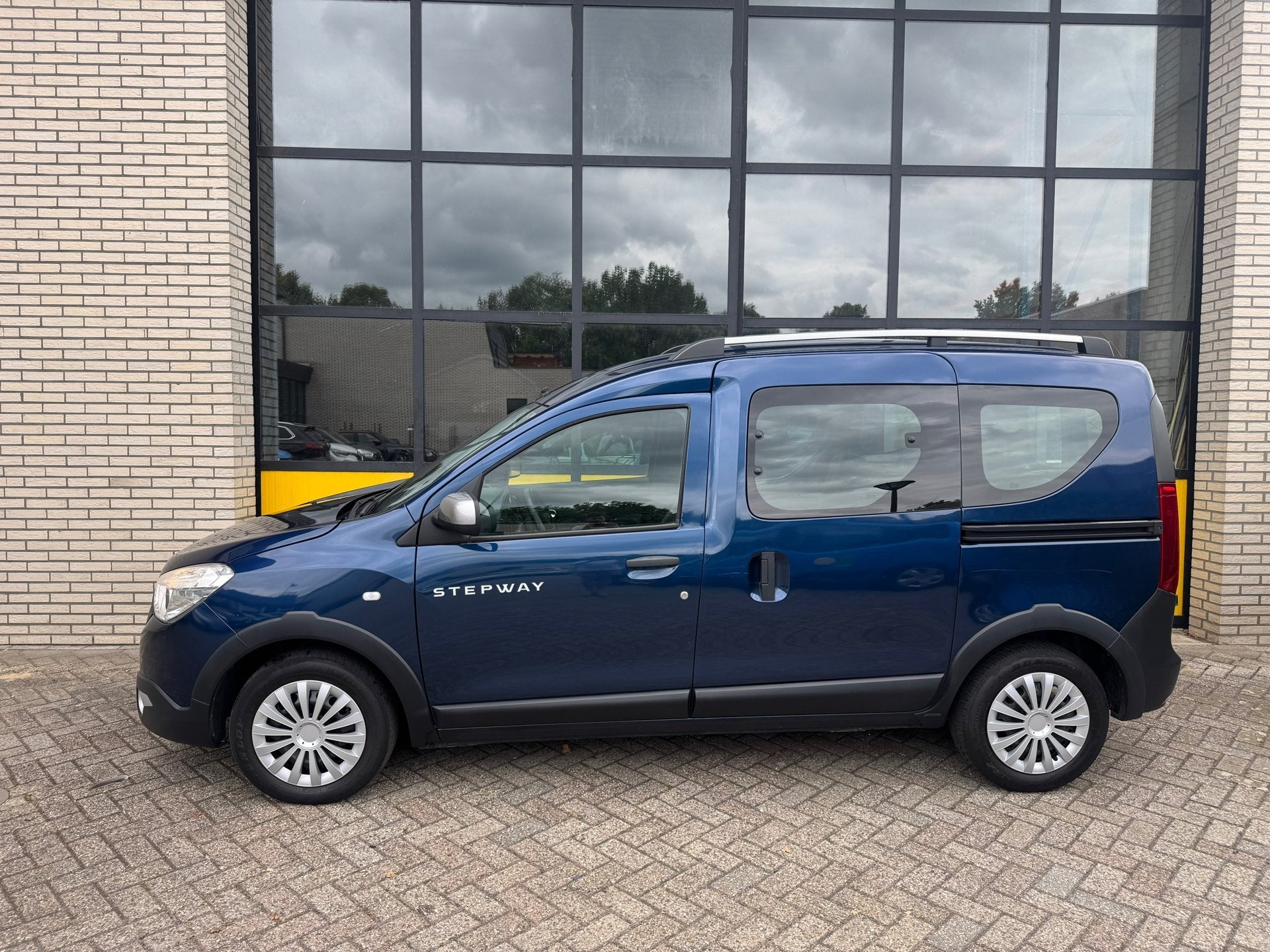 Dacia Dokker 103PK Série Limitée Stepway, Navi & cruise, Auto's, Dacia, Voorwielaandrijving, Stof, Gebruikt, Zwart