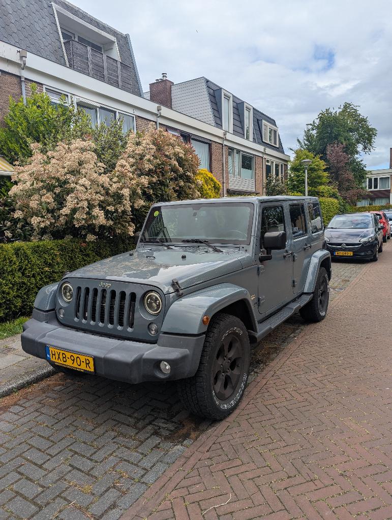 Jeep Wrangler Unlimited Sahara 2016 Anvil Grijs, Auto's, Automaat, Zwart, Stoelverwarming, Leder en Stof