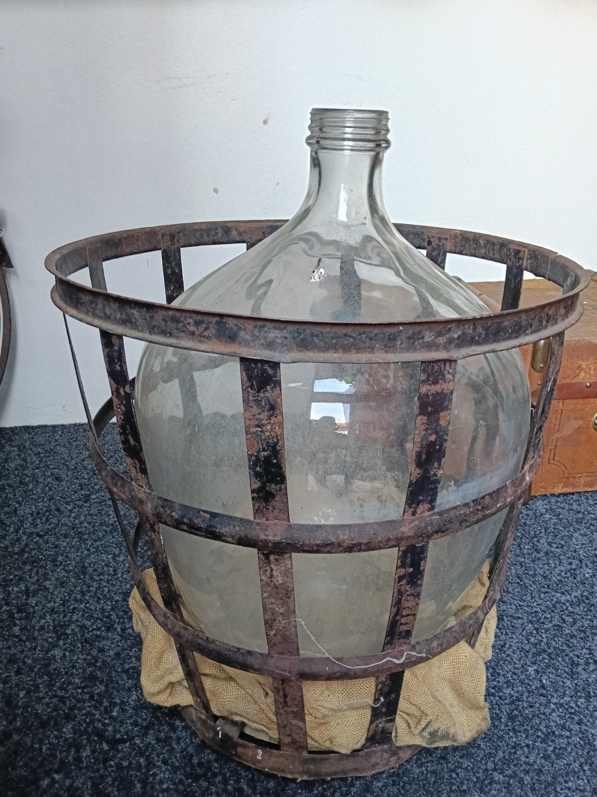 Grote glazen fles in metalen mand op wieltjes, Ophalen of Verzenden