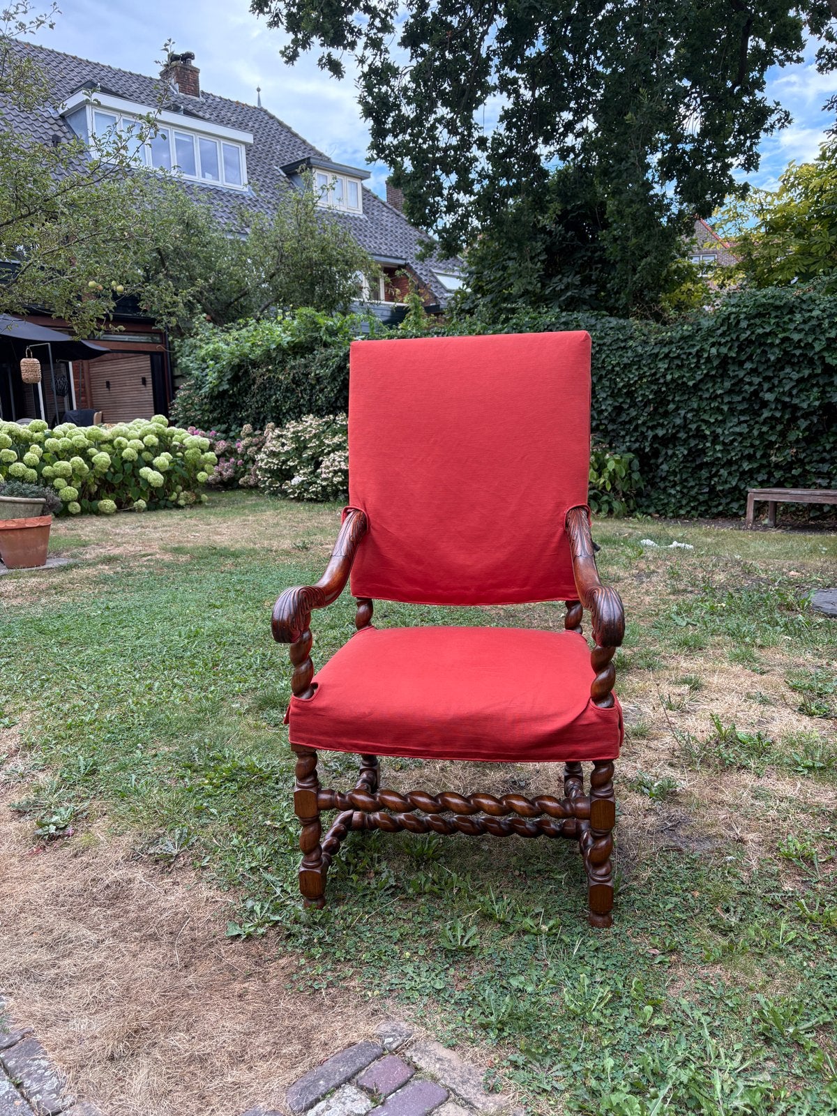 Antieke fauteuil met gedraaide poten en rode hoes, Ophalen