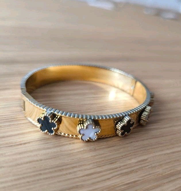Goudkleurige roestvrijstalen bangle armband met klavertjes, IJzer of Staal, Nieuw, Ophalen of Verzenden, 17 tot 18