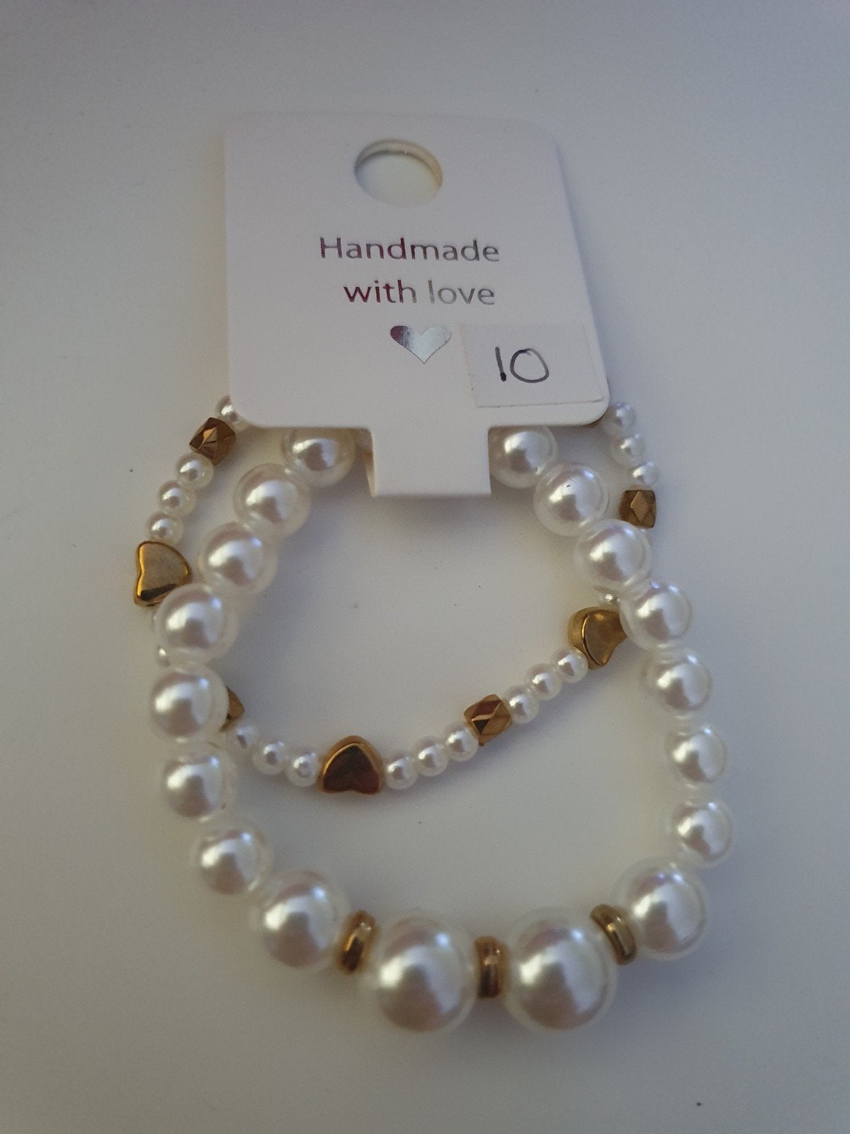 Armbandjes set wit met goudkleurig accenten - opbrengst Kika, Overige materialen, Wit, Nieuw, Ophalen of Verzenden