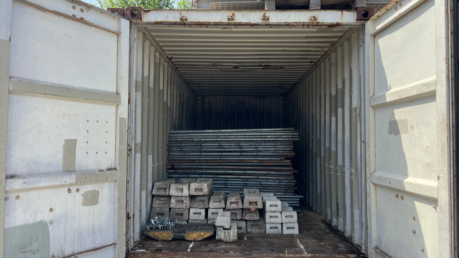 Zeecontainer 20ft met bouwhekken, voeten en klemmen, Ophalen