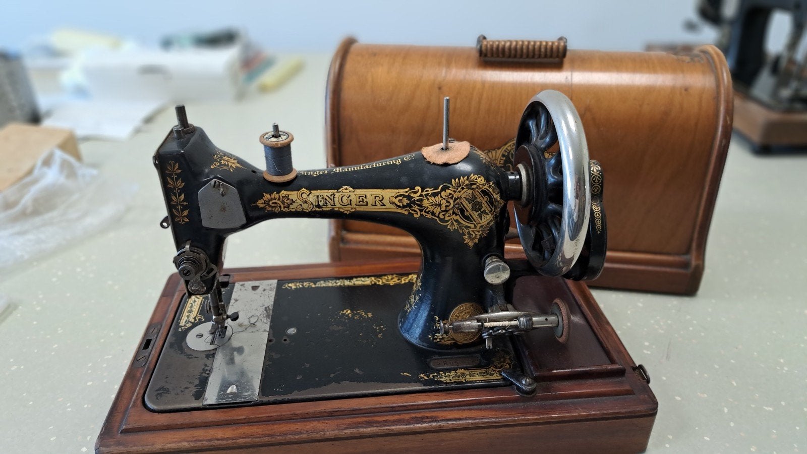 Antieke naaimachine van het merk Singer., Ophalen