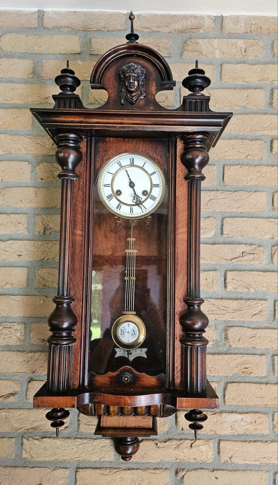 Antieke wandklok met slinger en houtsnijwerk, Ophalen