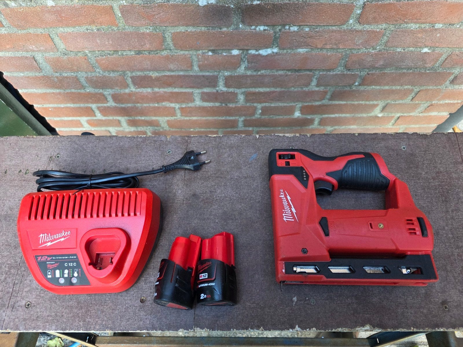 Milwaukee M12 BST tacker met lader en 2x 2.0Ah accu's, Ophalen of Verzenden, Gebruikt