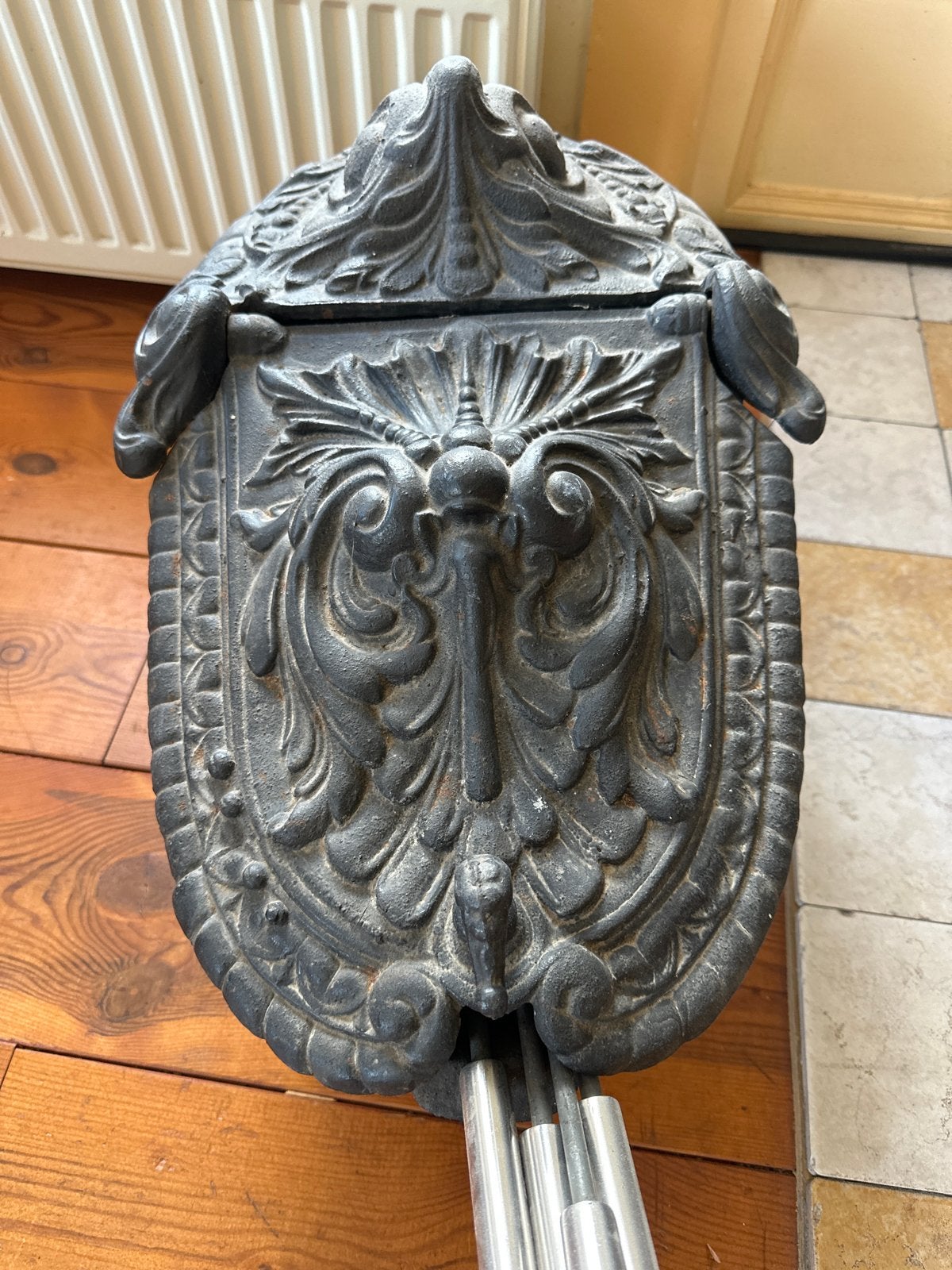 Antieke gietijzeren haardemmer met decoratieve motieven, Ophalen