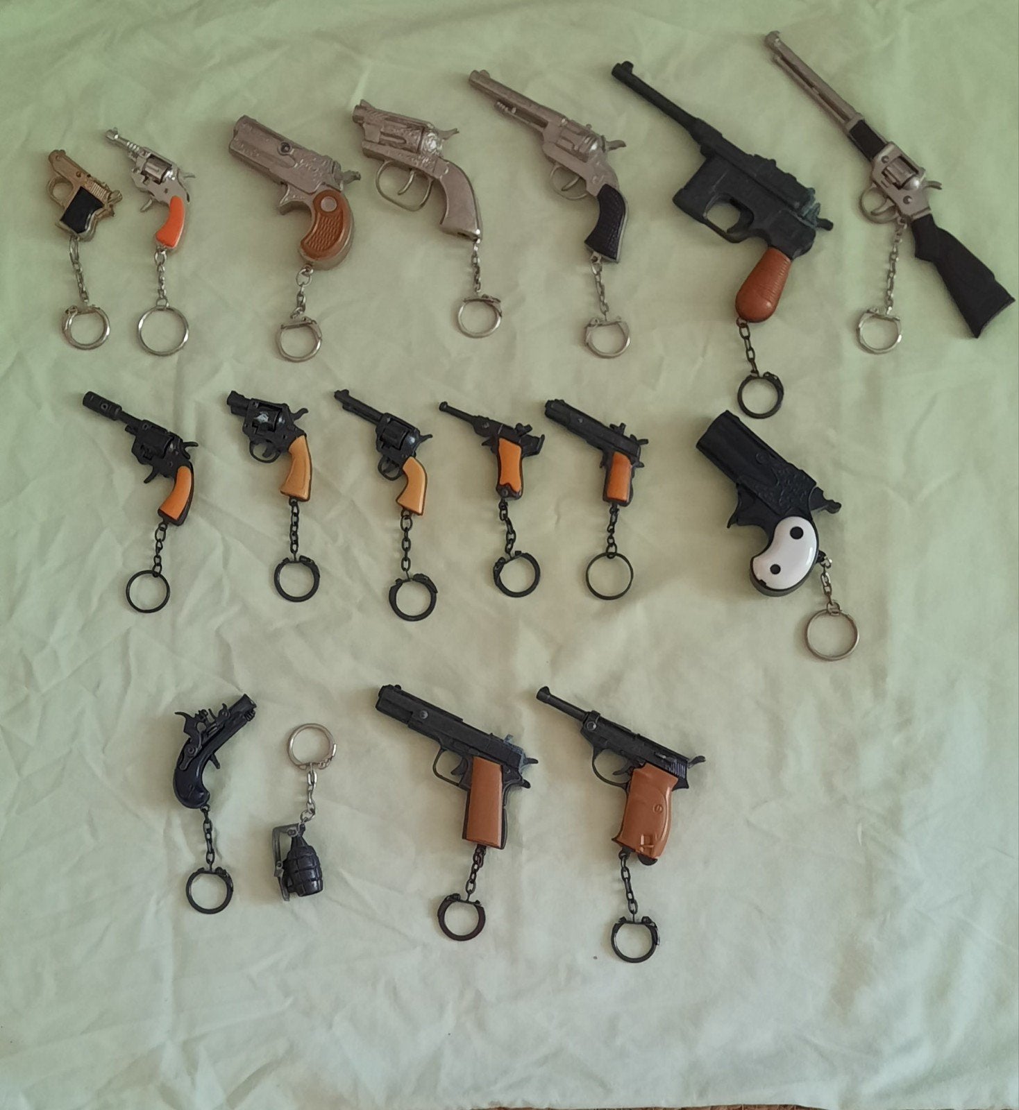 Verzameling sleutelhangers, pistooltjes en 1 handgranaat, Ophalen of Verzenden