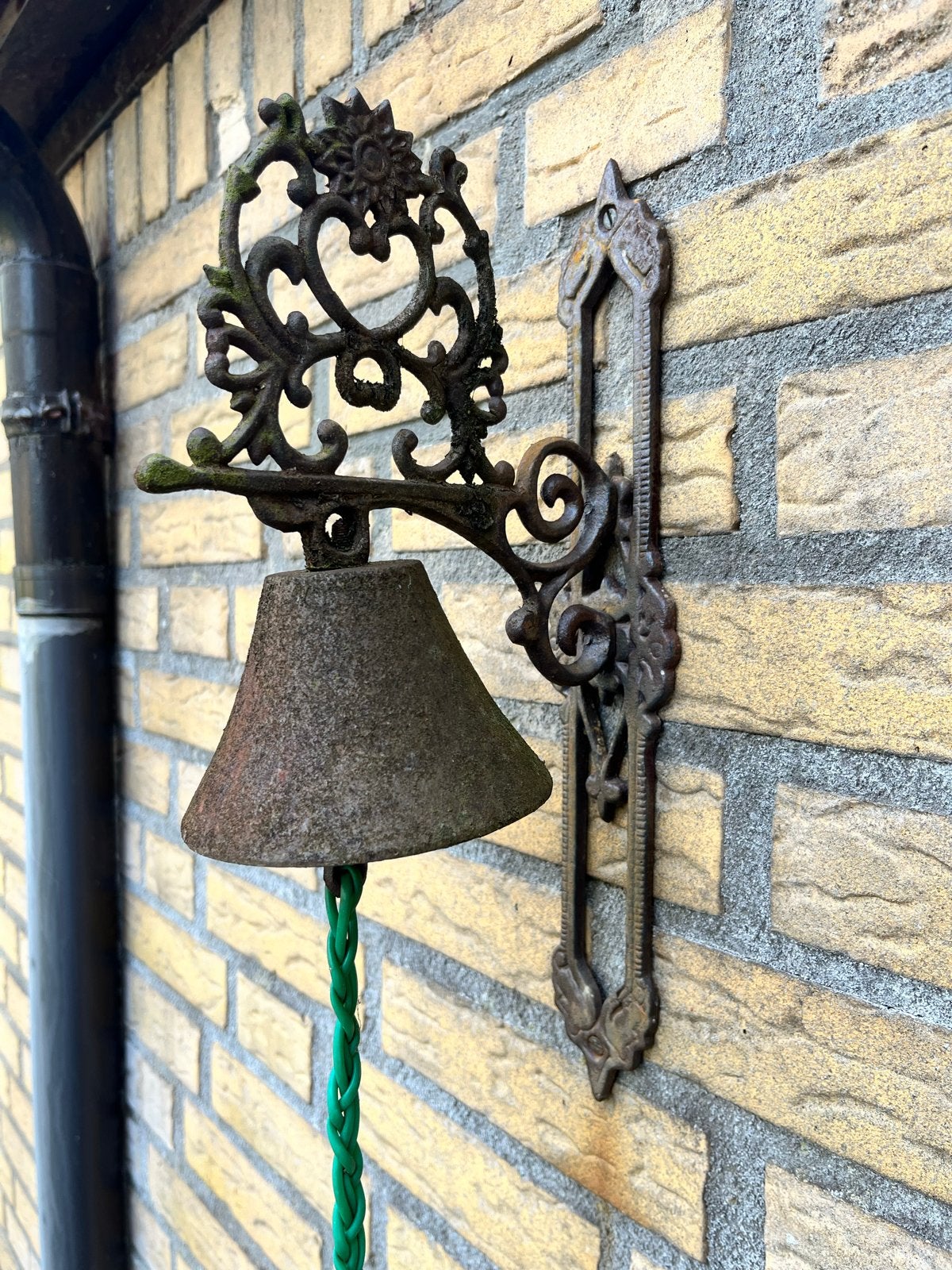 Antieke gietijzeren deurbel met sierlijke wandbevestiging, Antiek en Kunst, Antiek | Overige Antiek, Ophalen of Verzenden