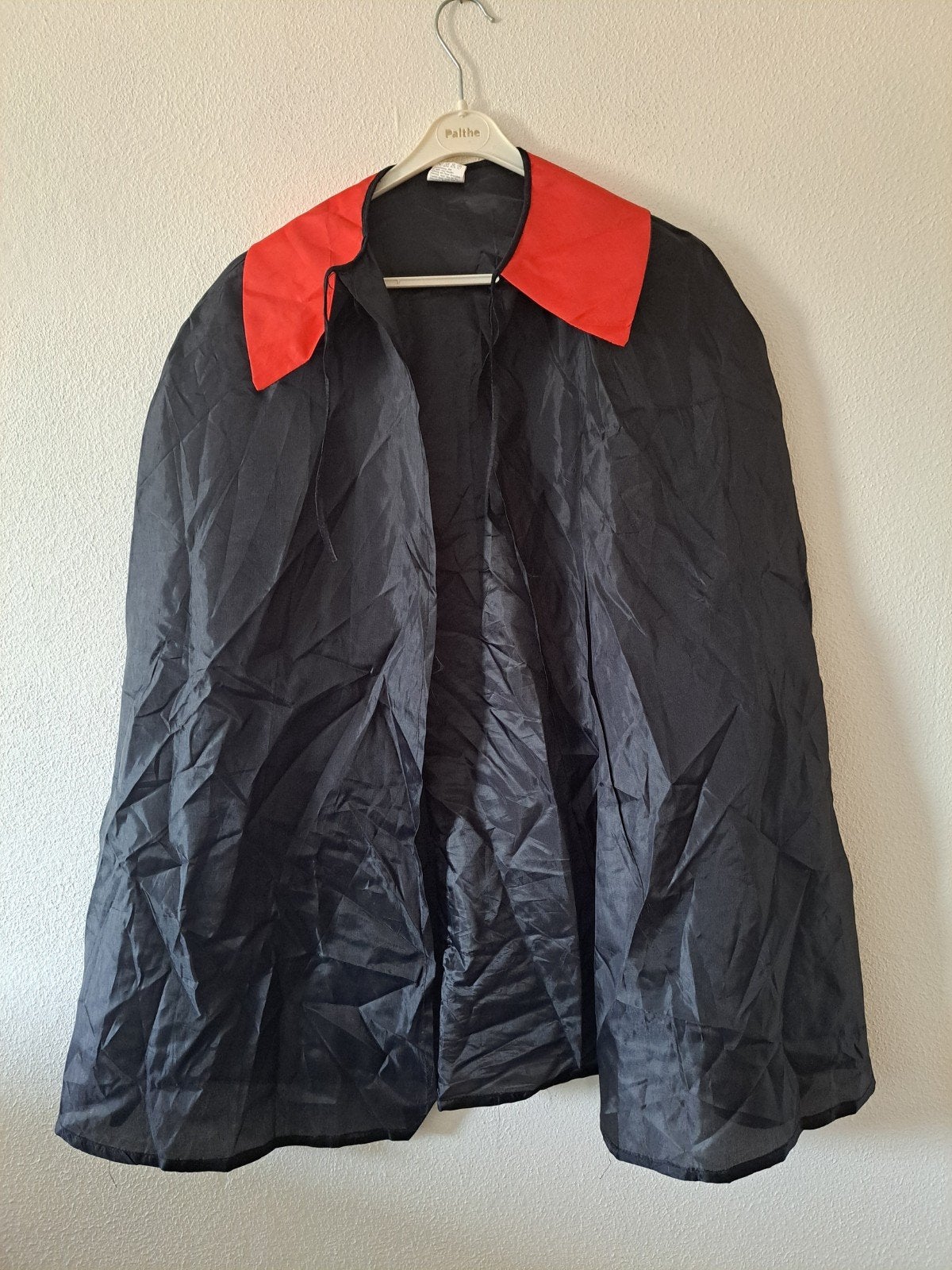 Zwarte cape met rode kraag - Maat 140, Kinderen en Baby's, Carnavalskleding en Verkleedspullen, Ophalen of Verzenden, Gebruikt