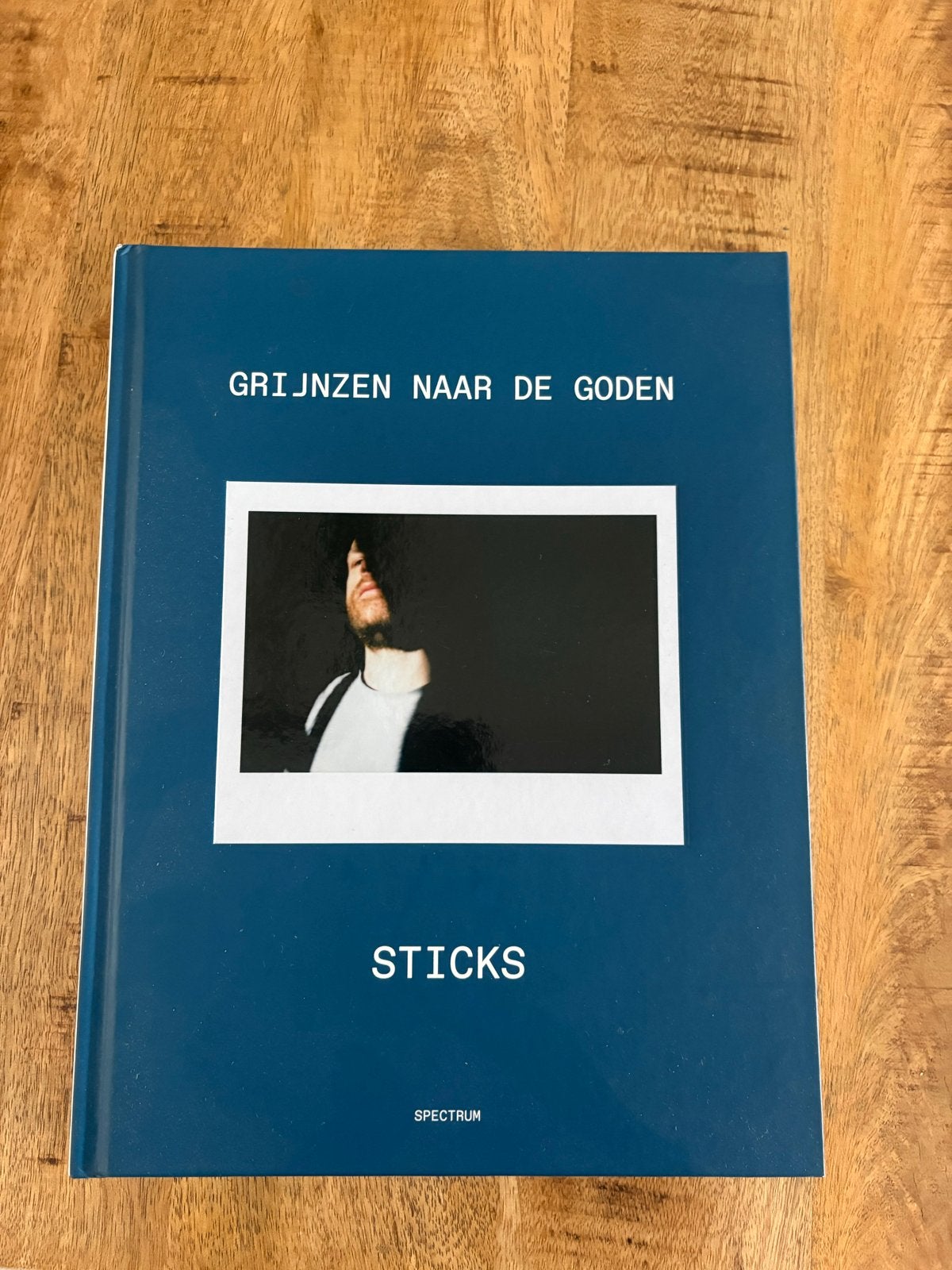 Grijnzen naar de Goden - Sticks (Boek), Ophalen of Verzenden, Zo goed als nieuw, Nederland
