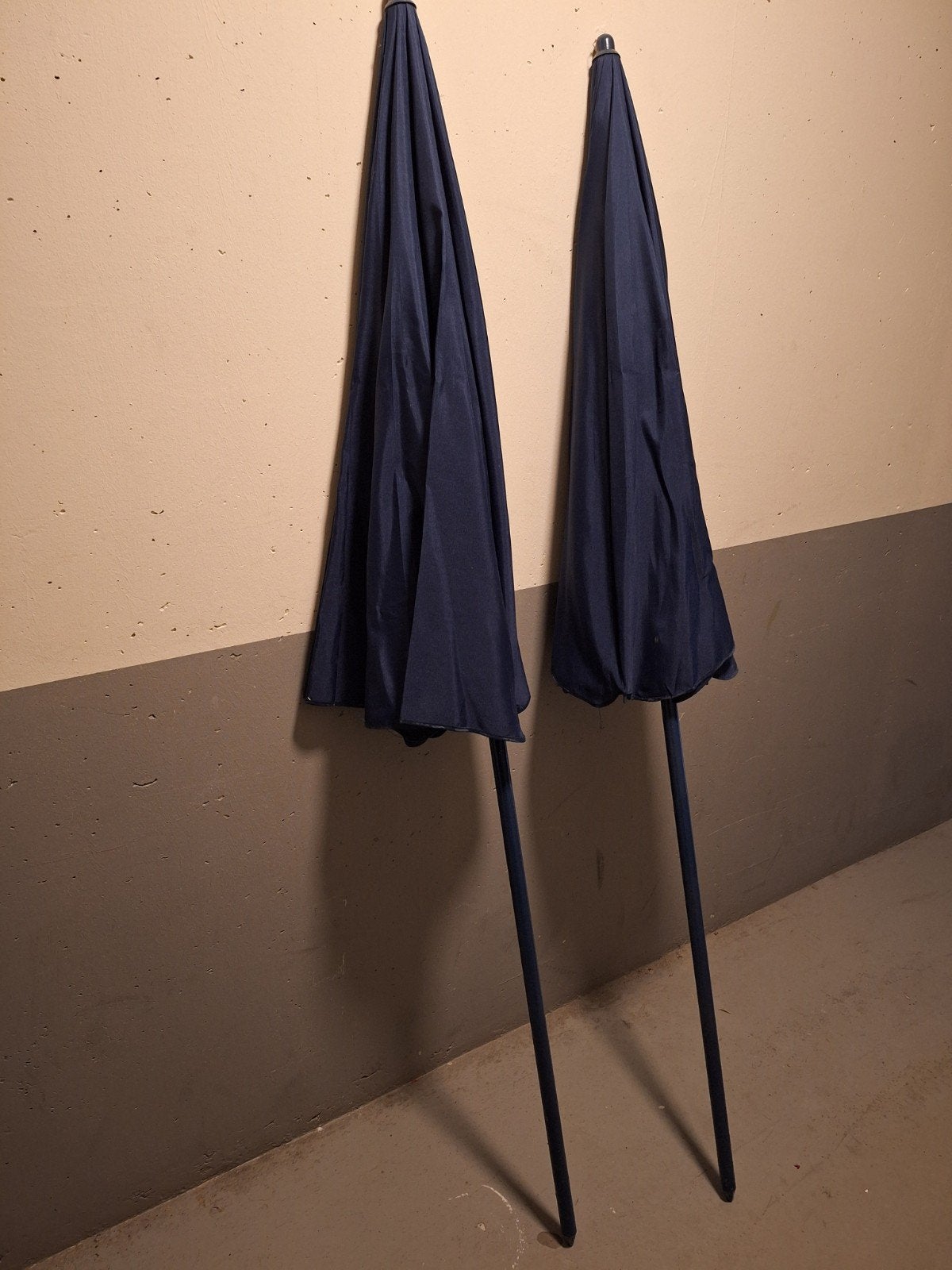 Twee donkerblauwe stokparasols