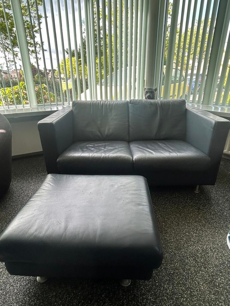 Te koop; lederen donkerblauw 2 sitter met bijpassende hocker, Ophalen, Zo goed als nieuw, Leer