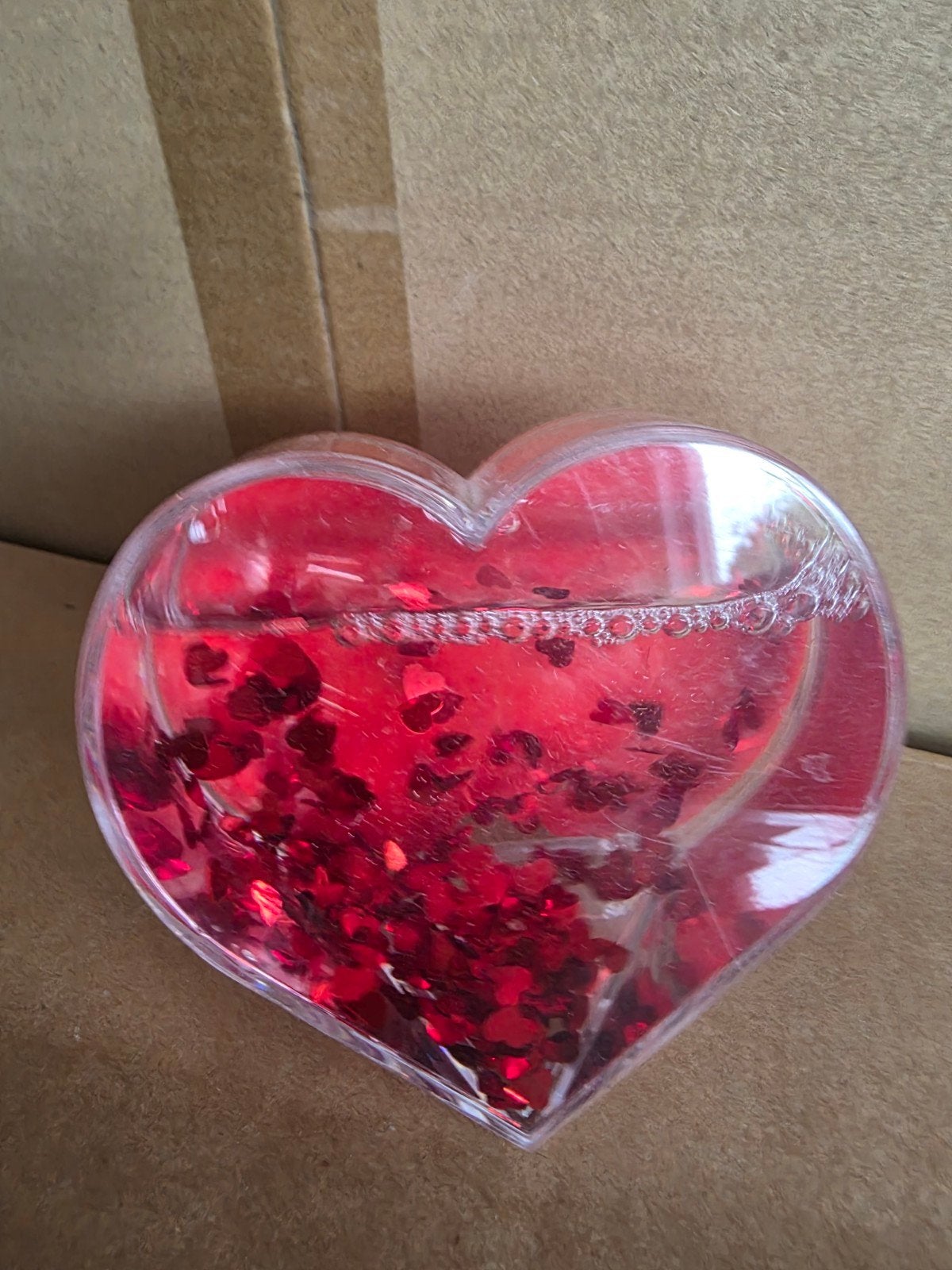 Hartvormige waterbol met rode hartvormige glitters, Ophalen