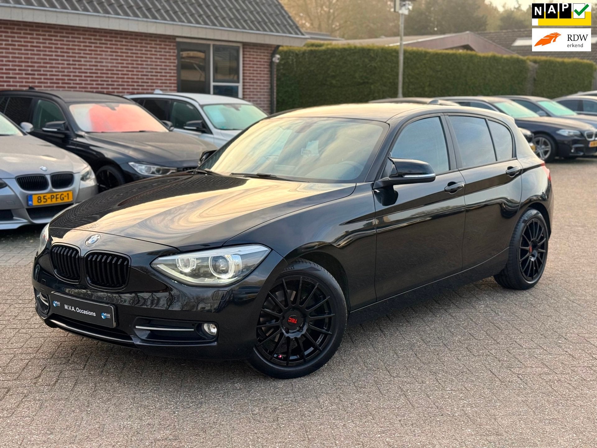 BMW 1-serie 114i EDE Corporate Lease Edition Sport|Nieuwe Ke, Auto's, 1-Serie, Gebruikt, 4 cilinders, Zwart