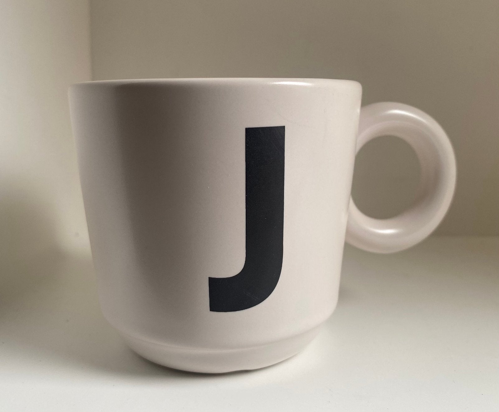 Hema mok met zwarte letter J op voorzijde. Hoogte 8 cm, Hema, Zo goed als nieuw, Overige stijlen, Aardewerk