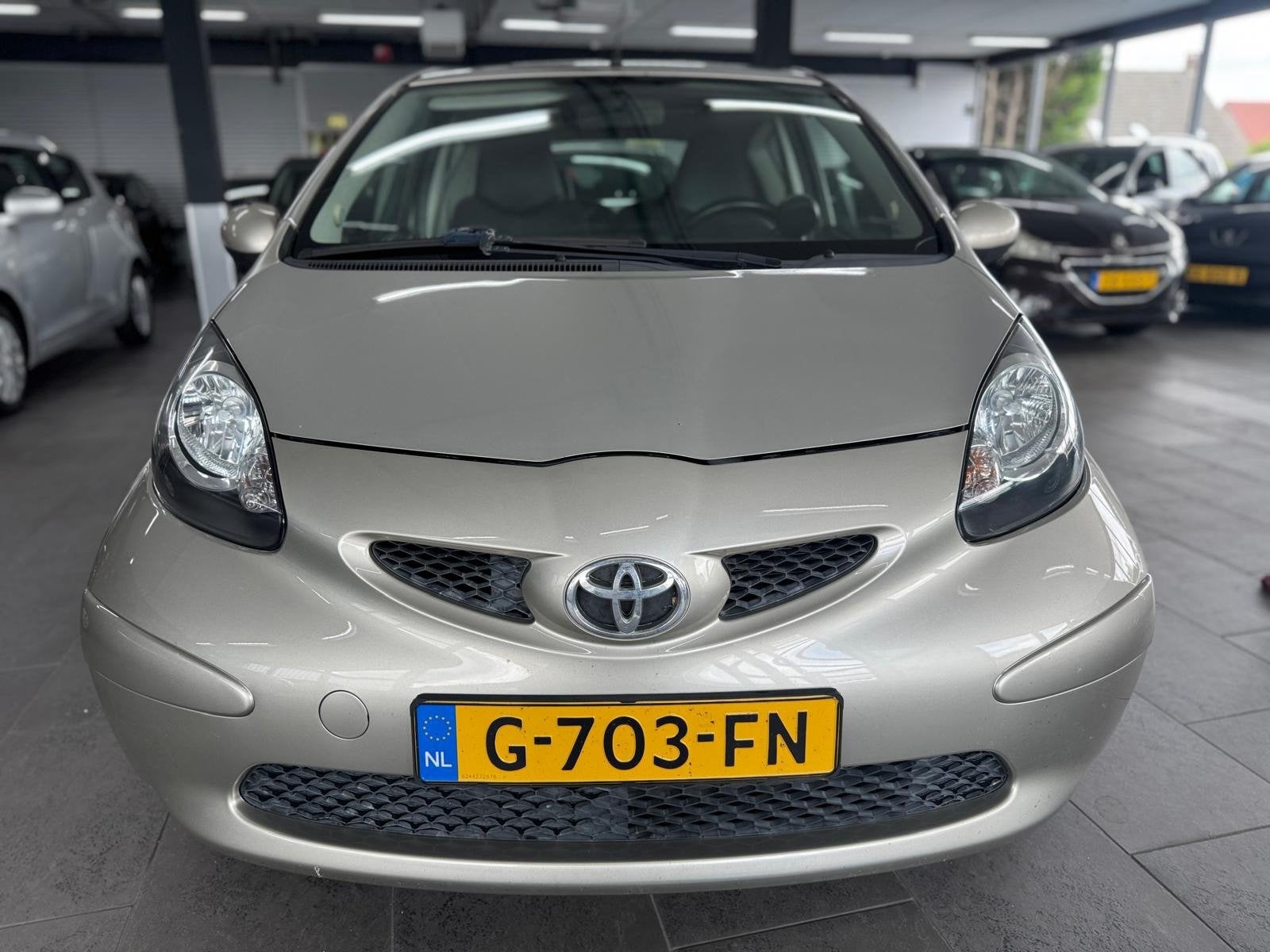 Toyota Aygo 1.0-12V + airco elektrische pakket half leer lm-, Auto's, Voorwielaandrijving, Gebruikt, Bruin, 4 stoelen