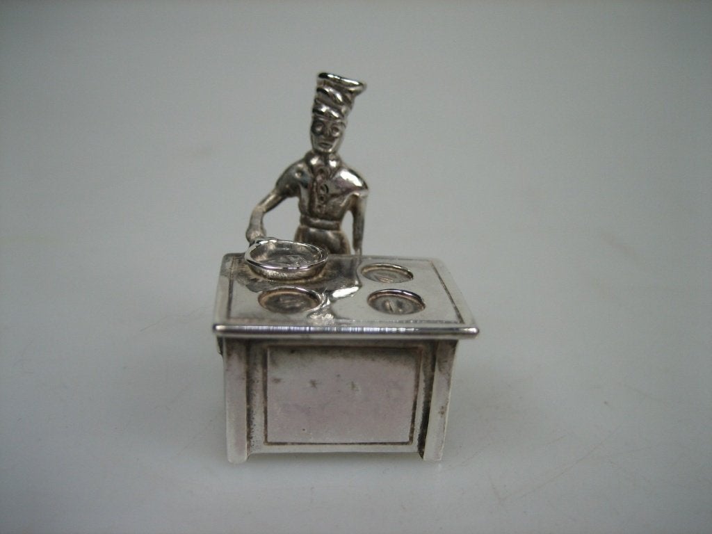 Zilveren miniatuur, kok bij het fornuis uit ca. 1975