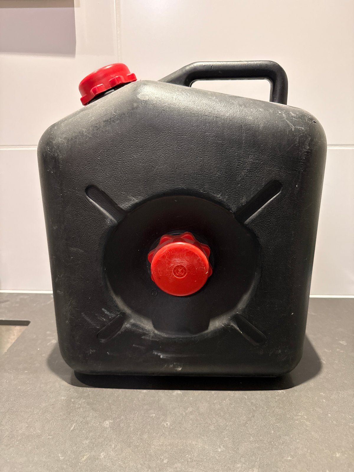 Zwarte jerrycan met rode doppen, Ophalen