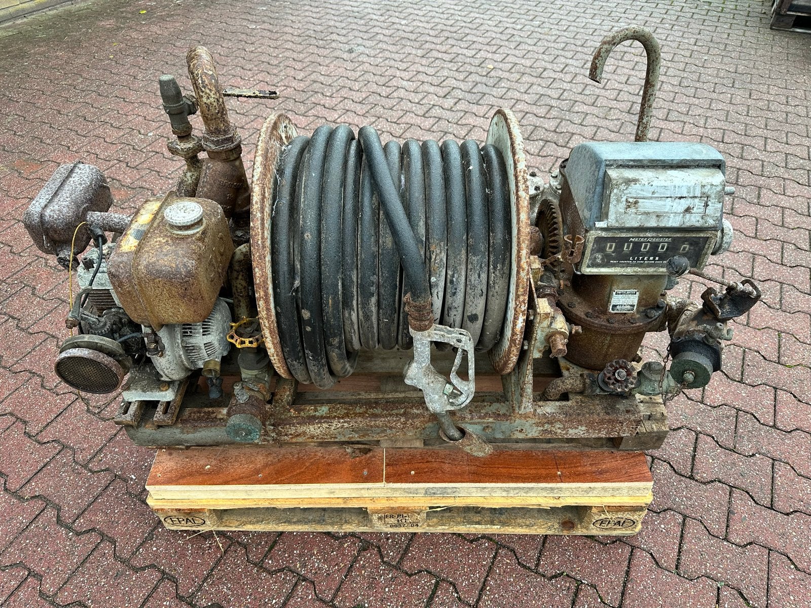 Oude brandstofpomp met slanghaspel en motor, Ophalen