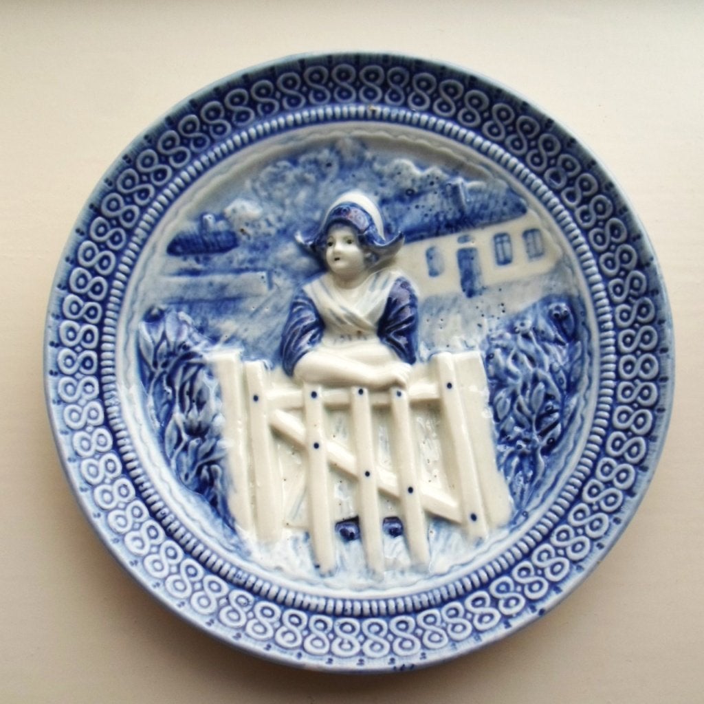 Muurplaat. Delfts blauw. In reliëf. Boerin leunend op hekje., Ophalen of Verzenden