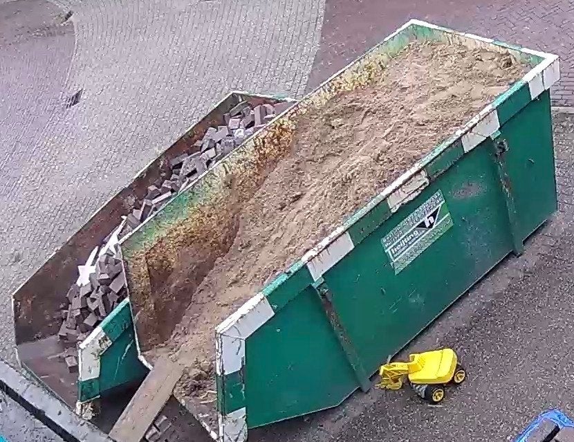 Gevulde bouwcontainer met zand en stenen, Ophalen