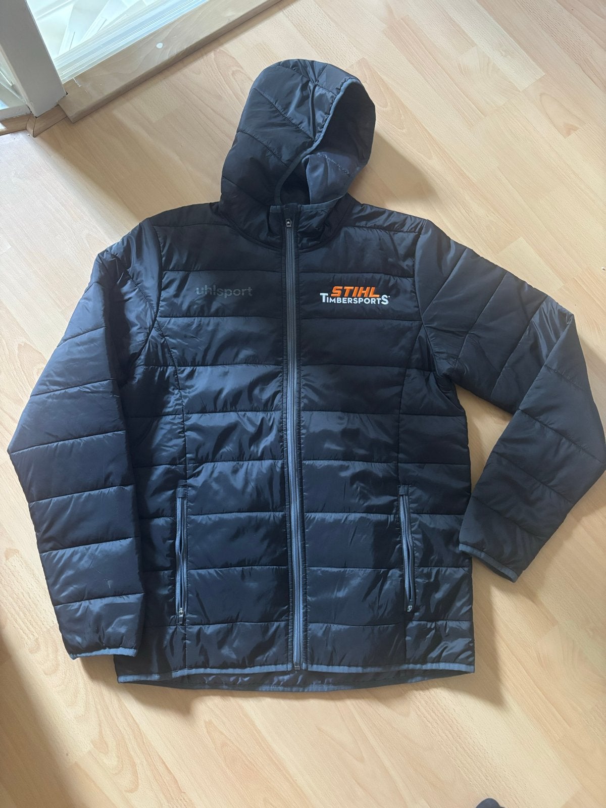 Uhlsport Stihl Timbersports Jas - Maat L, Ophalen of Verzenden, Nieuw, Maat 52/54 (L), Zwart